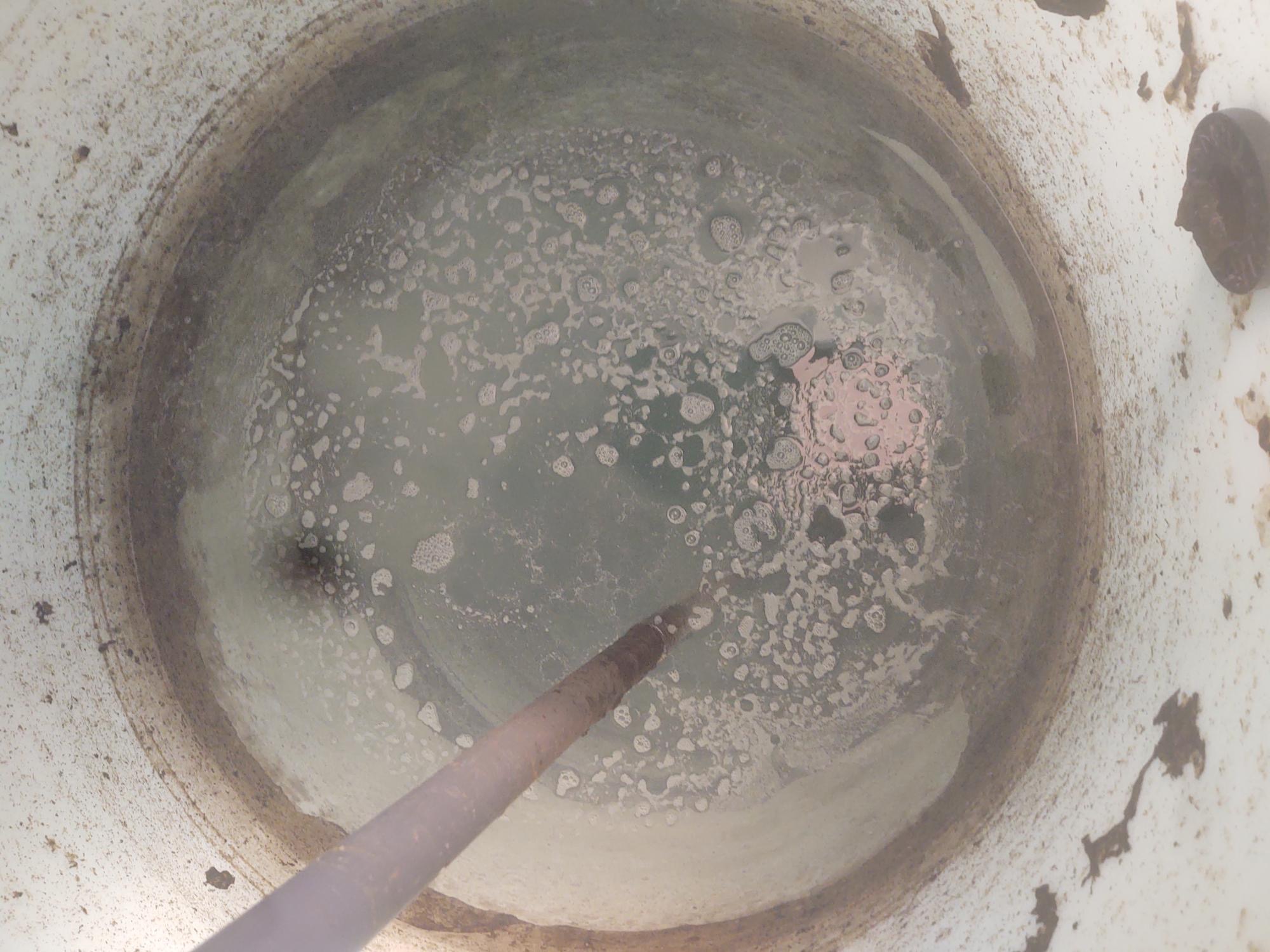 Reservoir tank before FERTox treatment — biofilm, scale, and debris visible